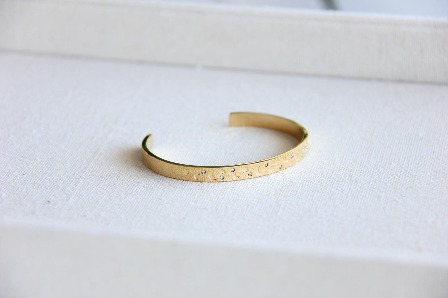 Gold and silver celestial cuff bracelet with star and moon engravings, adorned with sparkling crystals. A stylish cosmic-inspired accessory, perfect for stacking or wearing solo. Great celestial jewelry gift for women