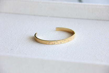 Gold and silver celestial cuff bracelet with star and moon engravings, adorned with sparkling crystals. A stylish cosmic-inspired accessory, perfect for stacking or wearing solo. Great celestial jewelry gift for women