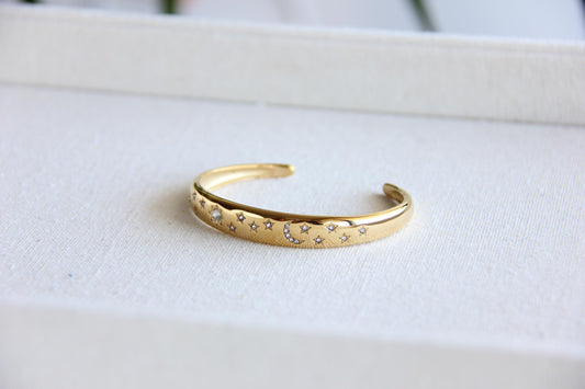 Gold and silver celestial cuff bracelet with star and moon engravings, adorned with sparkling crystals. A stylish celestial-inspired accessory, perfect for stacking or wearing solo. Great celestial jewelry gift for women