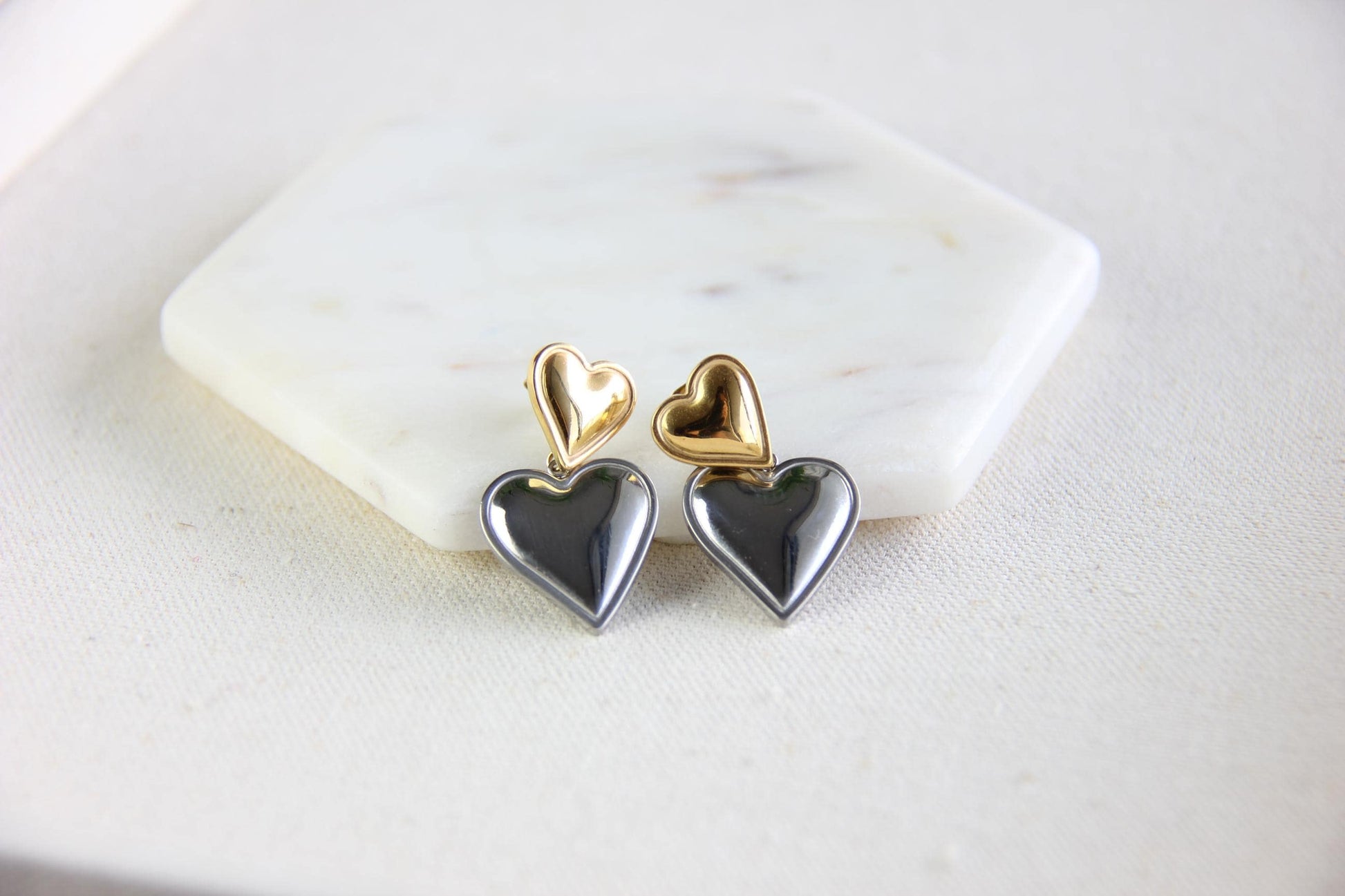 Two-color heart dangle drop earrings in gold and silver, featuring a stylish and modern design. Lightweight and elegant drop earrings, perfect for everyday wear or special occasions. Trendy perfect gift for women and girls who love unique jewelry.